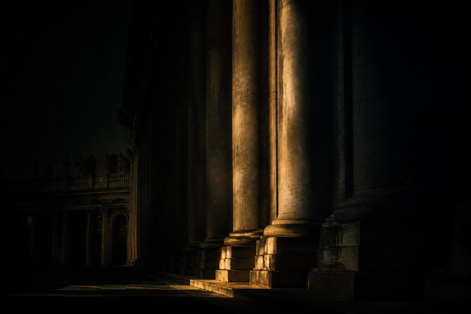 Cinematic classical colonnade lit by a single shaft of gold light